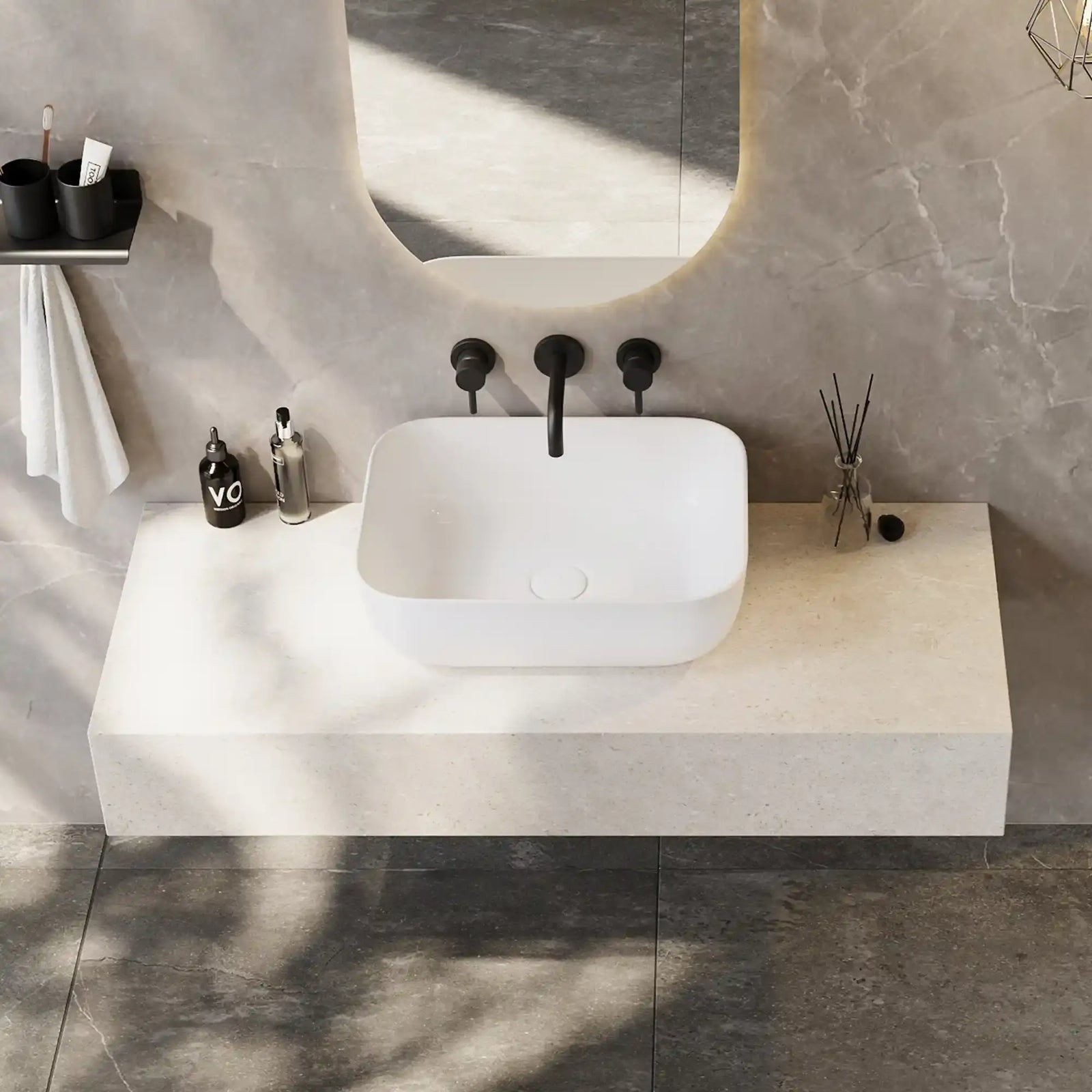 White rounded rectangle solid surface vessel sink with matte black three-hole wall mount faucet