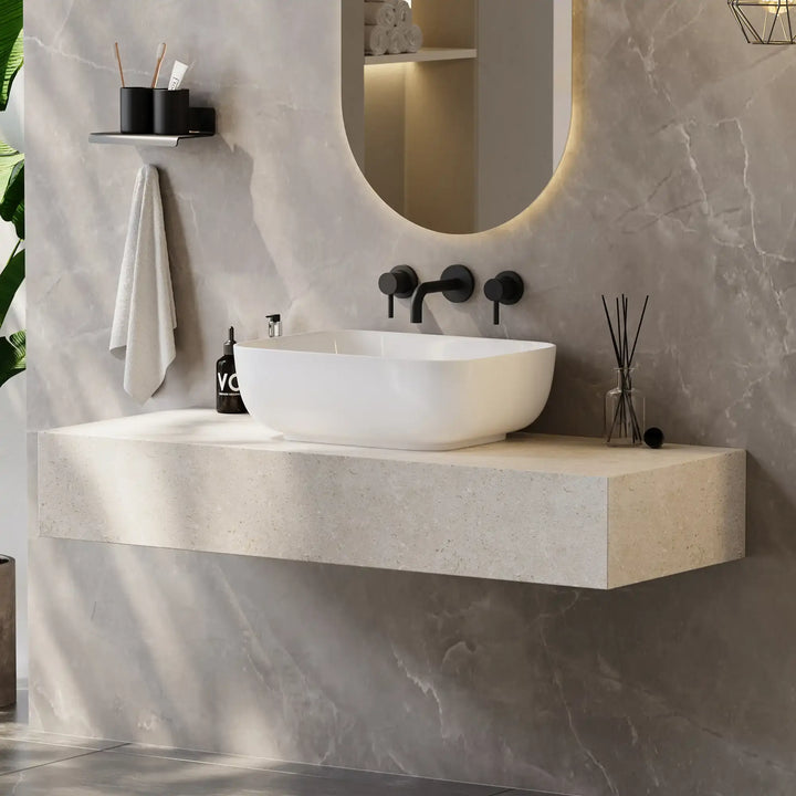 White rounded rectangular solid surface vessel sink matched with matte black wall-mounted bathroom faucet
