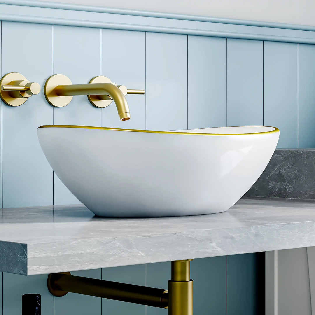 Glossy white oval ceramic vessel sink with thin gold rim border