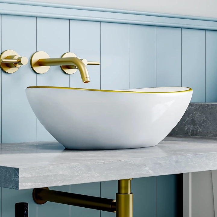 Glossy white oval ceramic vessel sink with thin gold rim border