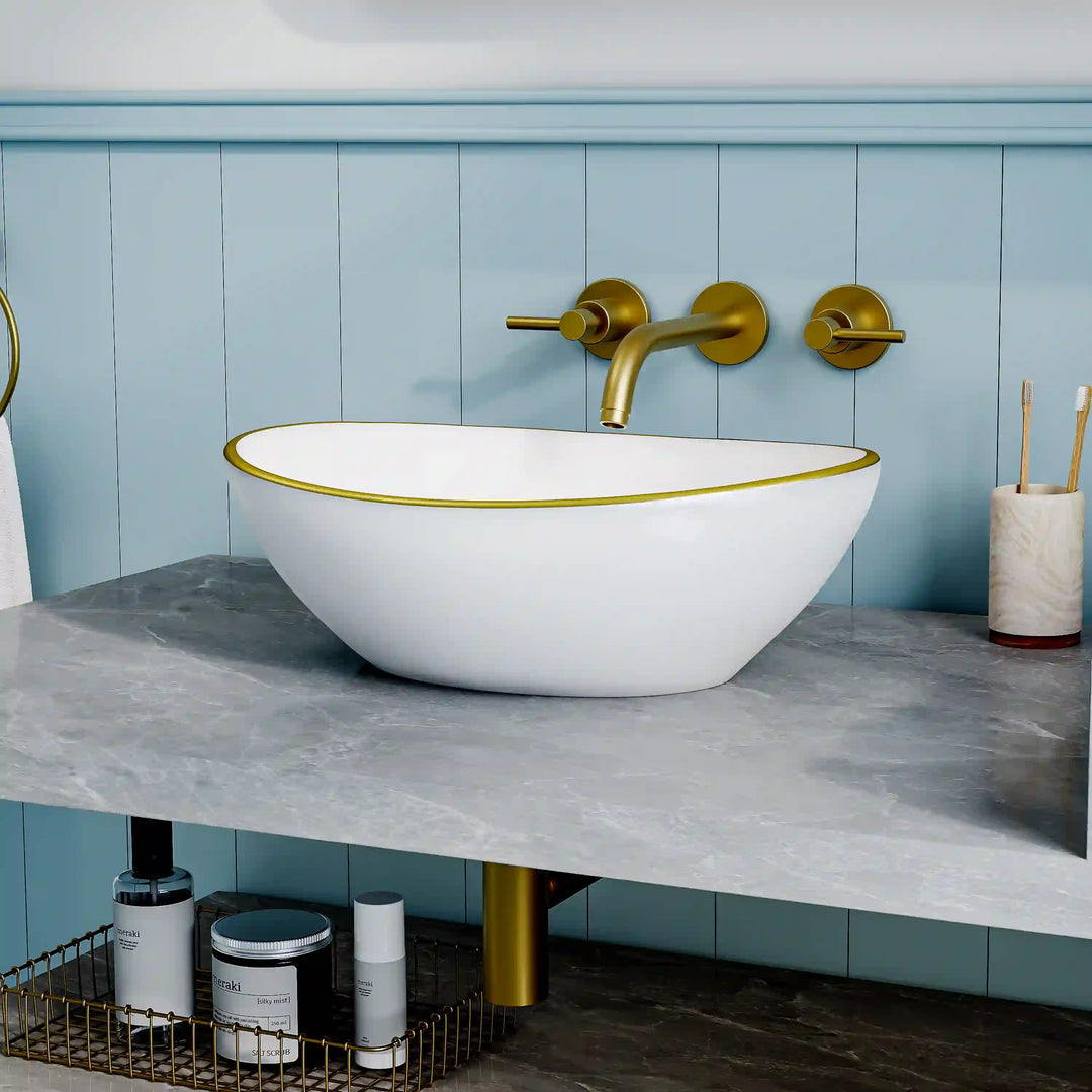 Glossy white oval ceramic vessel sink with thin gold rim border