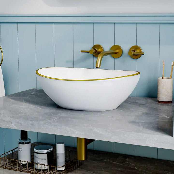 Glossy white oval ceramic vessel sink with thin gold rim border