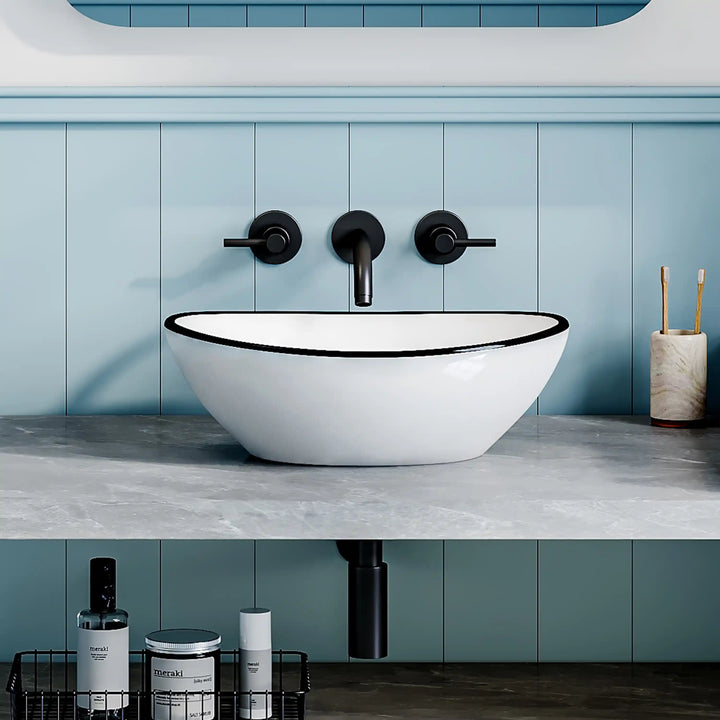 White ceramic oval vessel sink with thin black rim border, modern countertop wash basin
