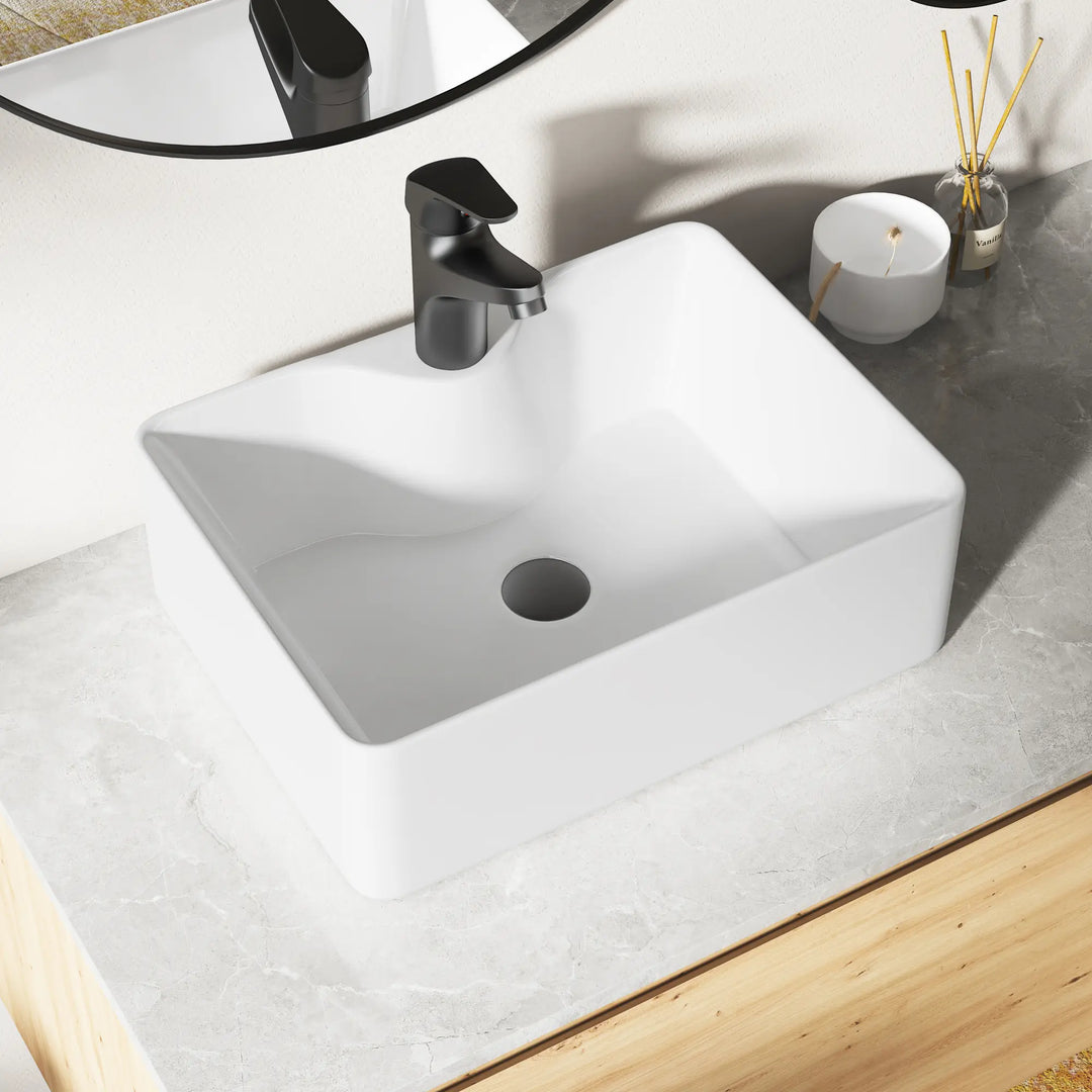 Eridanus white rectangular ceramic vessel sink with black faucet.