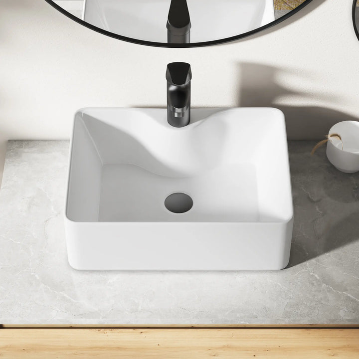 Eridanus white square ceramic vessel sink with black faucet.
