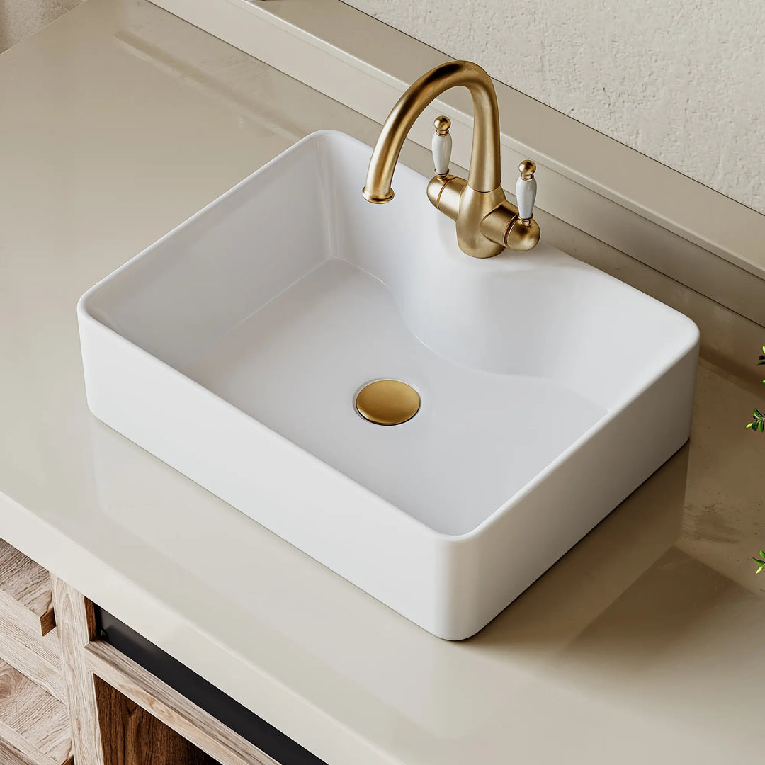 Double white ceramic vessel sinks with elegant gold faucets.