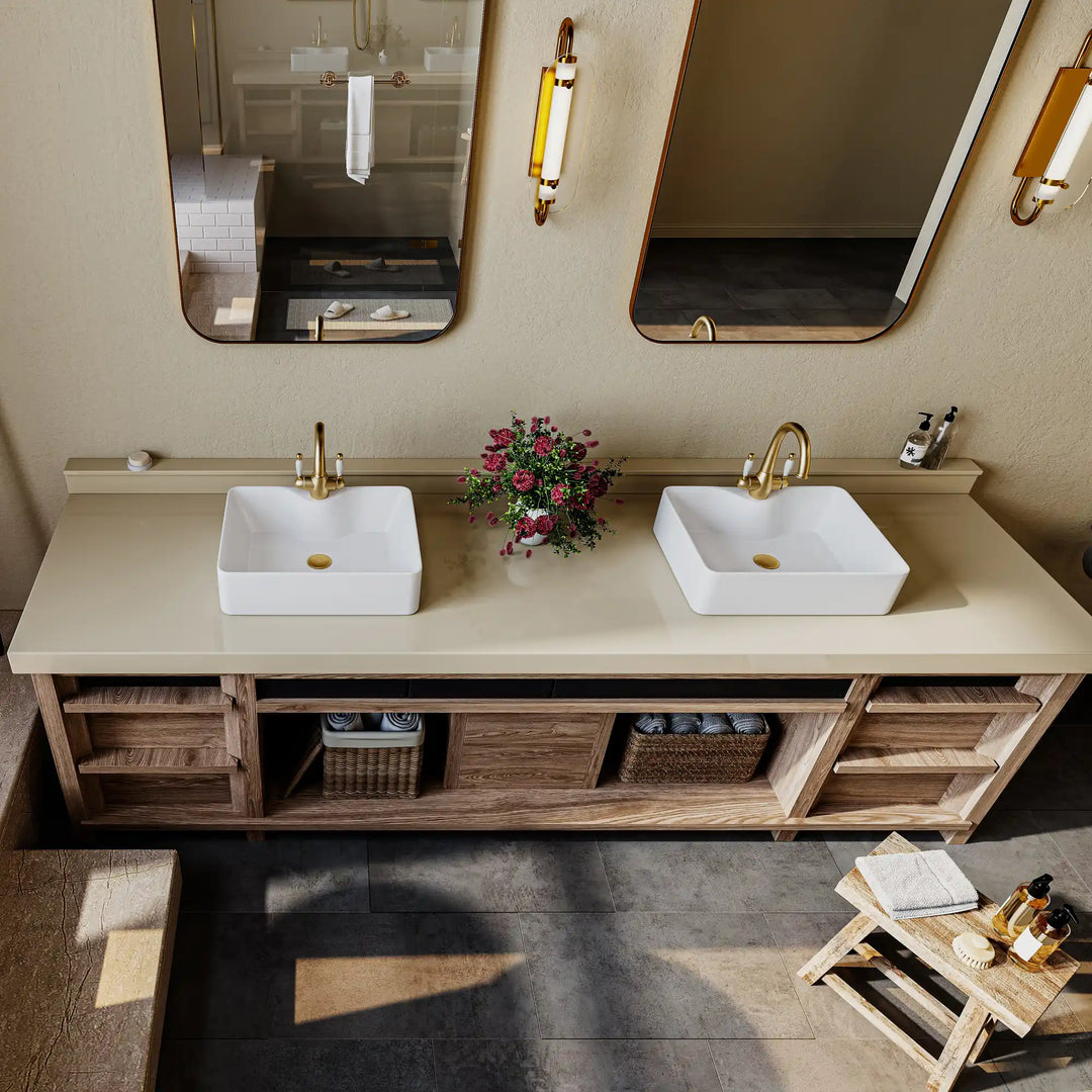 Double white ceramic vessel sinks with elegant gold faucets.