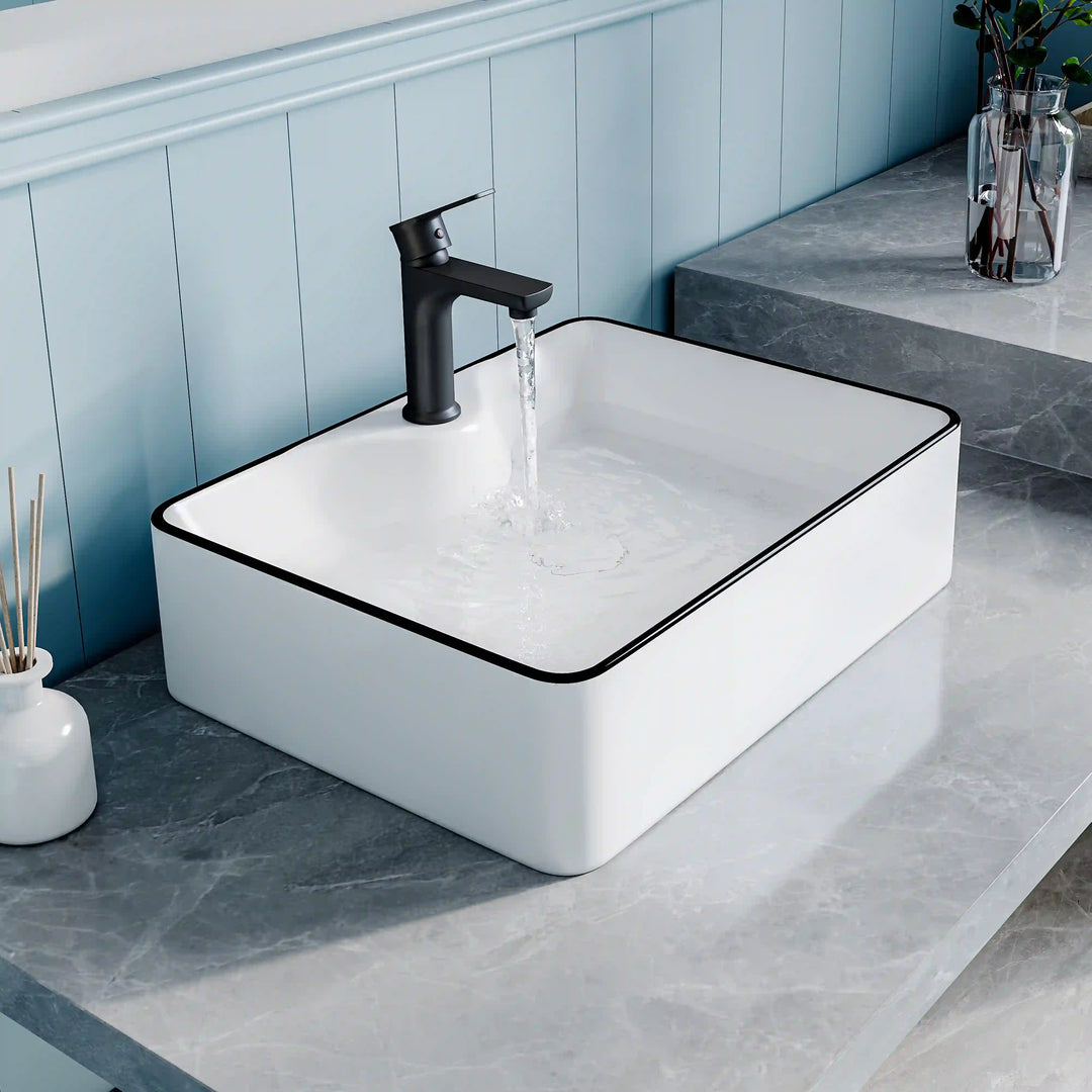White ceramic square countertop vessel sink with black thin edge trim, paired matte black faucet