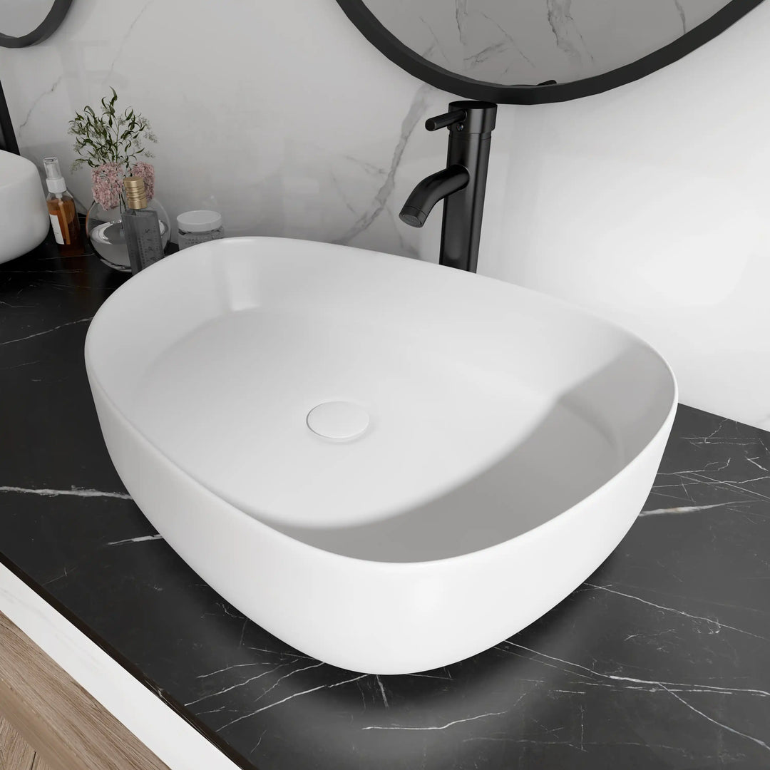 White matte irregular oval ceramic vessel sink with hidden round drain, modern bathroom wash basin