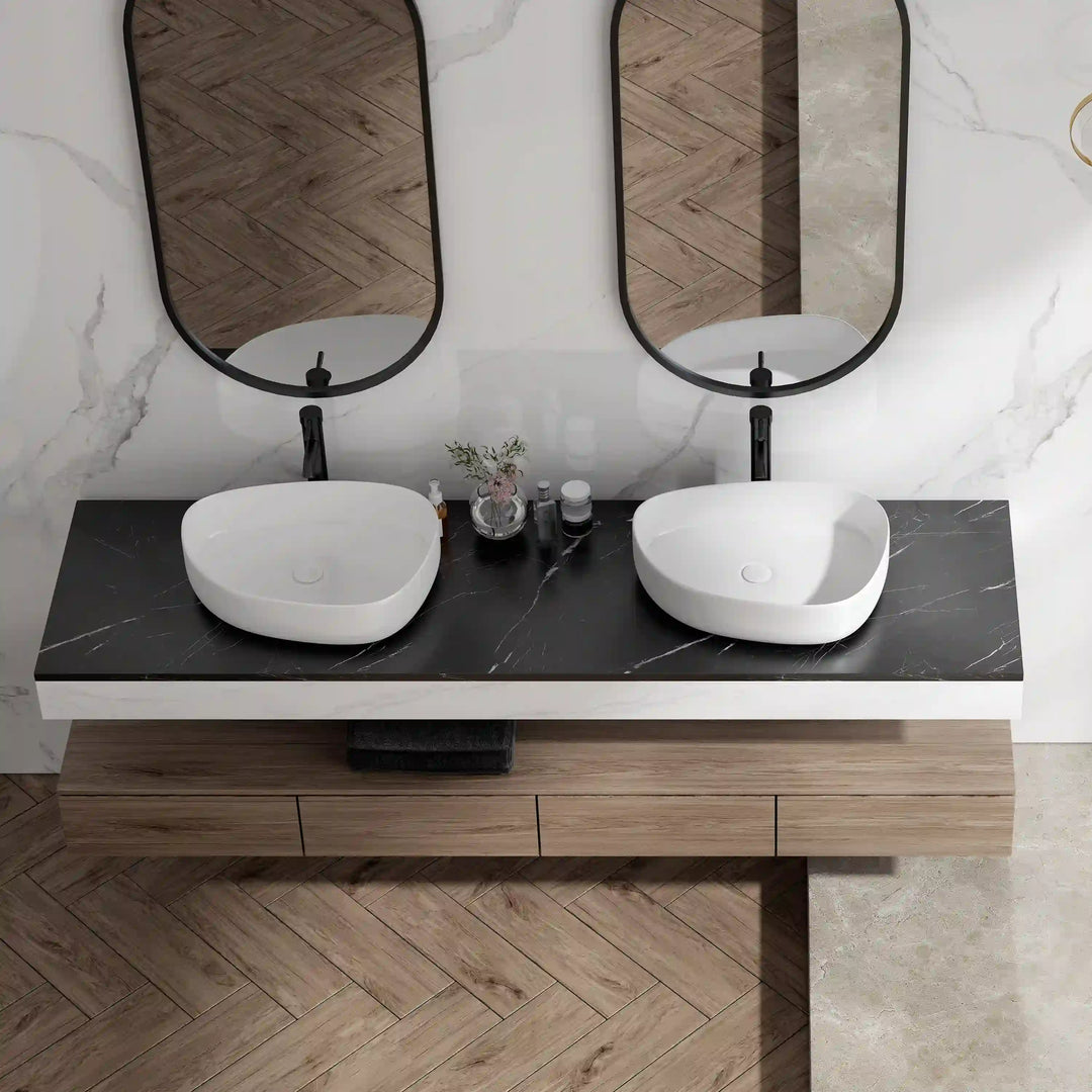 Two white matte oval ceramic vessel sinks with hidden drains, double countertop wash basins