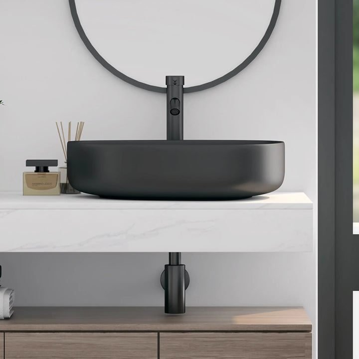 Matte black curved oval solid surface vessel sink side view