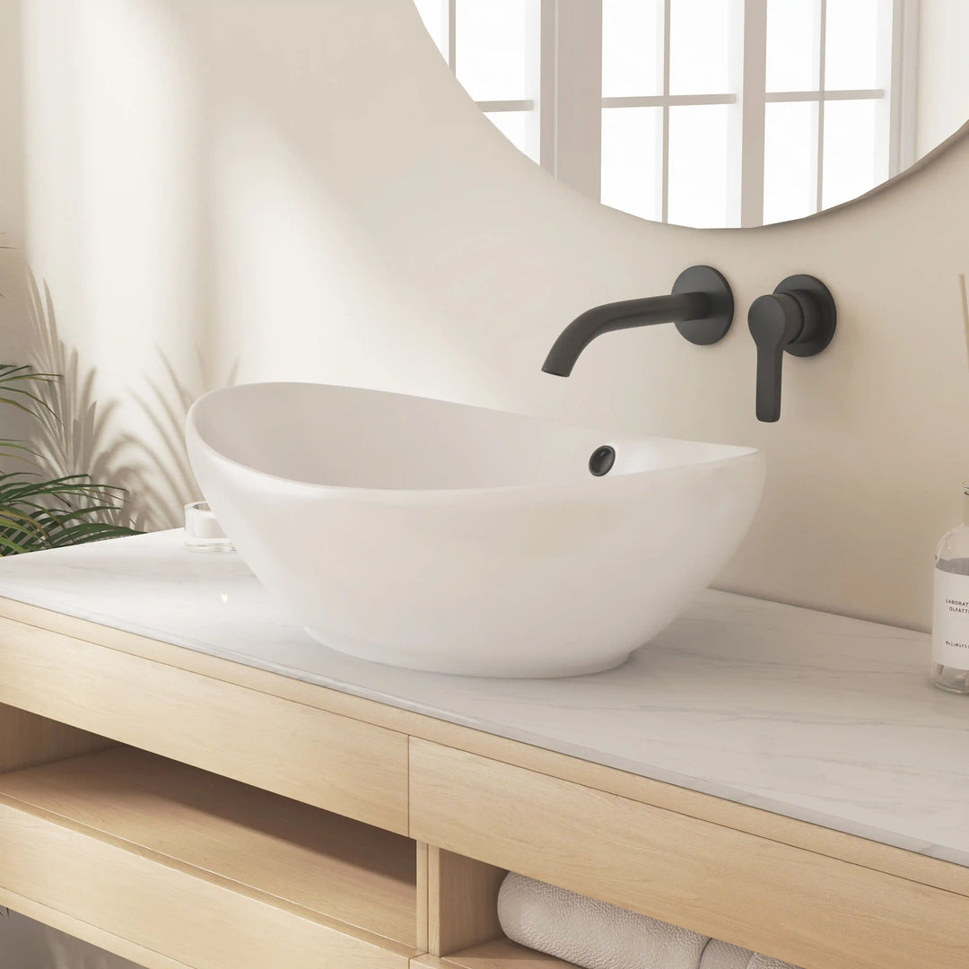 Glossy white curved ceramic vessel sink with matte black wall tap