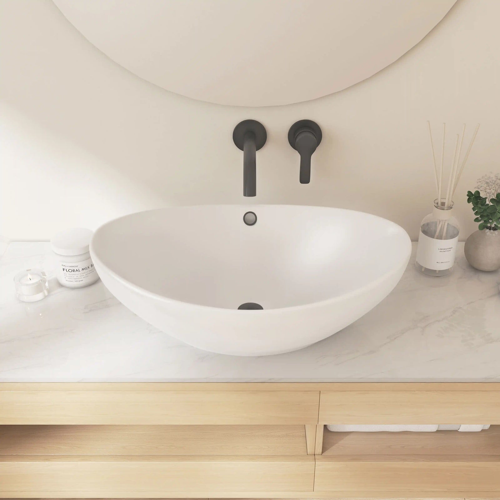 White oval ceramic vessel sink with overflow hole and wall-mounted matte black faucet