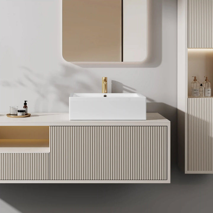 White rectangular ceramic vessel sink paired with brushed gold tall faucet