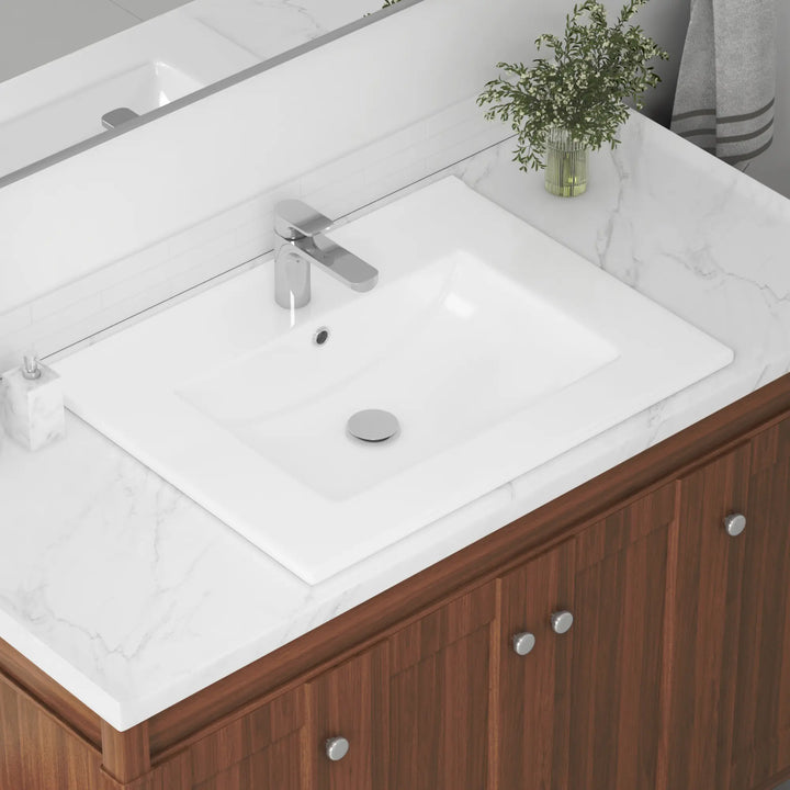 White rectangular vanity sink with single faucet hole and chrome drain.