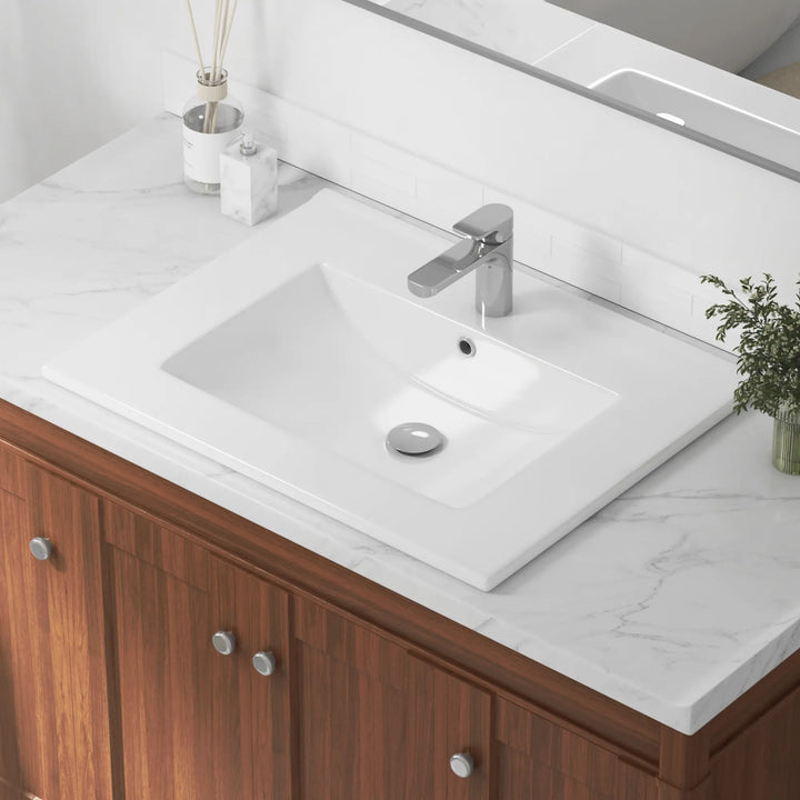 White rectangular vanity sink with single faucet hole and chrome drain.
