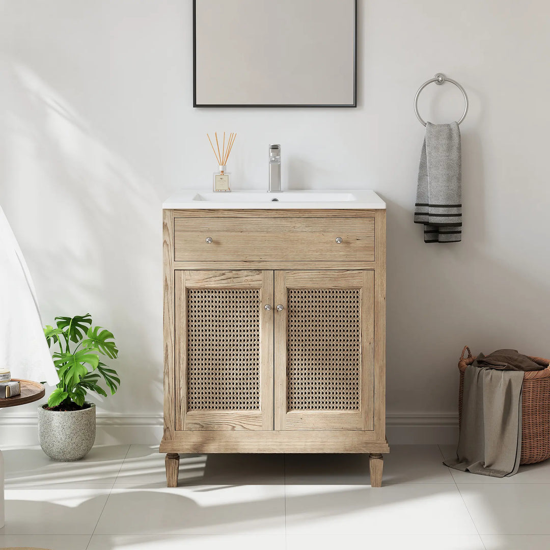 White bathroom vanity sink atop a light wood cabinet with rattan doors.
