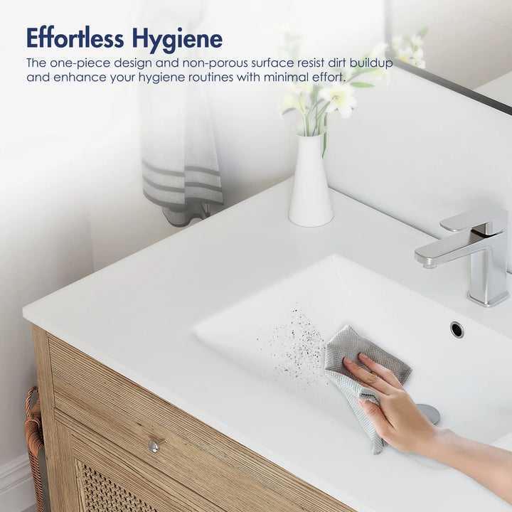 Wiping dirt off a white non-porous integrated bathroom sink.