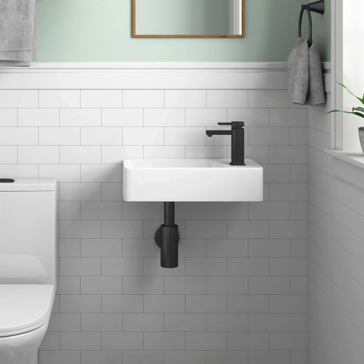 Wall-mounted white ceramic sink with matte black faucet