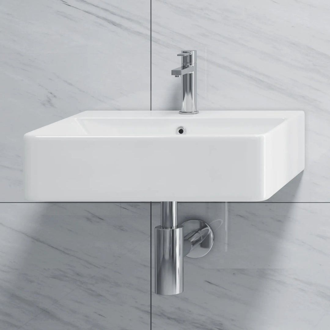 Wall-mount white ceramic sink with chrome faucet and trap.