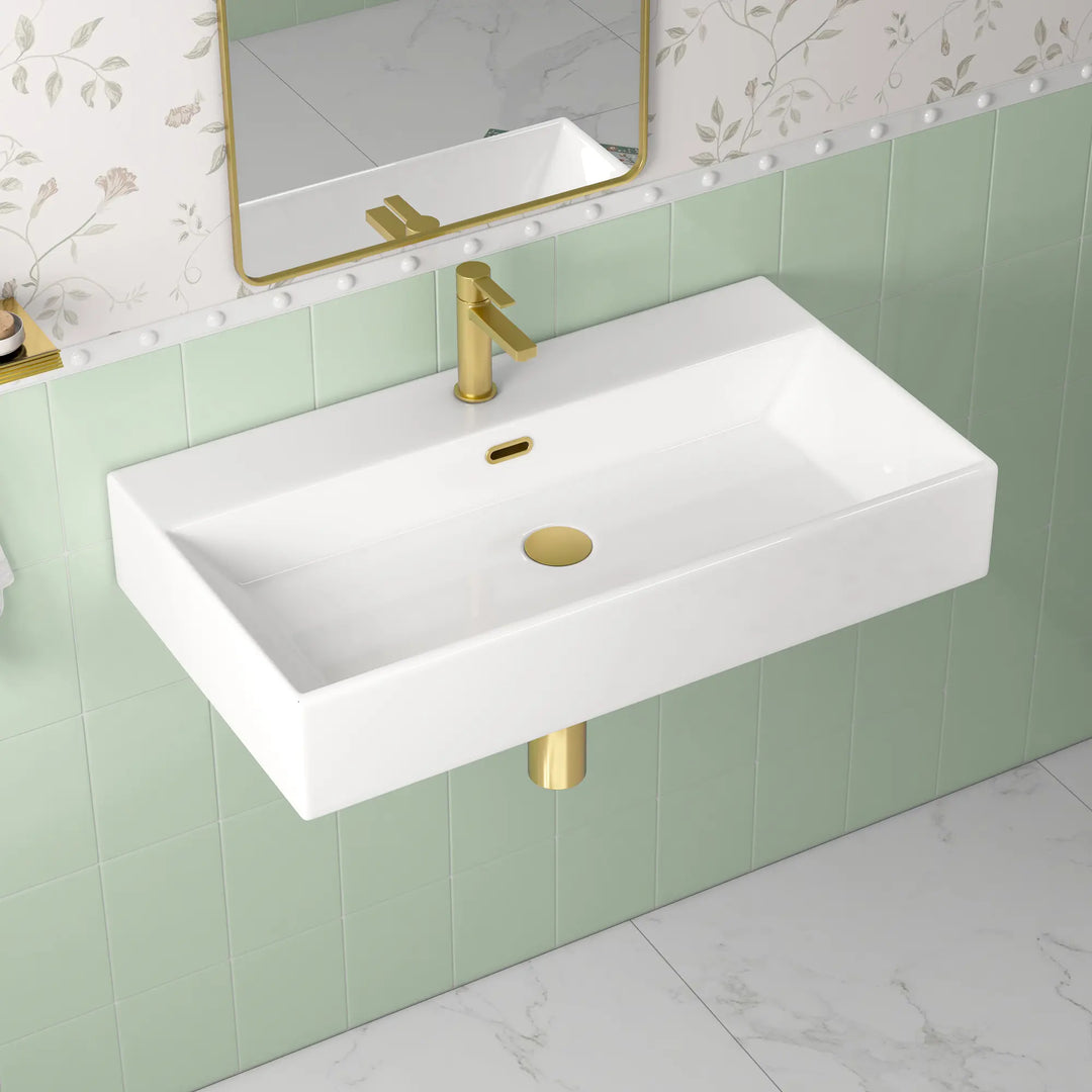 White rectangular wall-mount sink with single hole gold faucet.