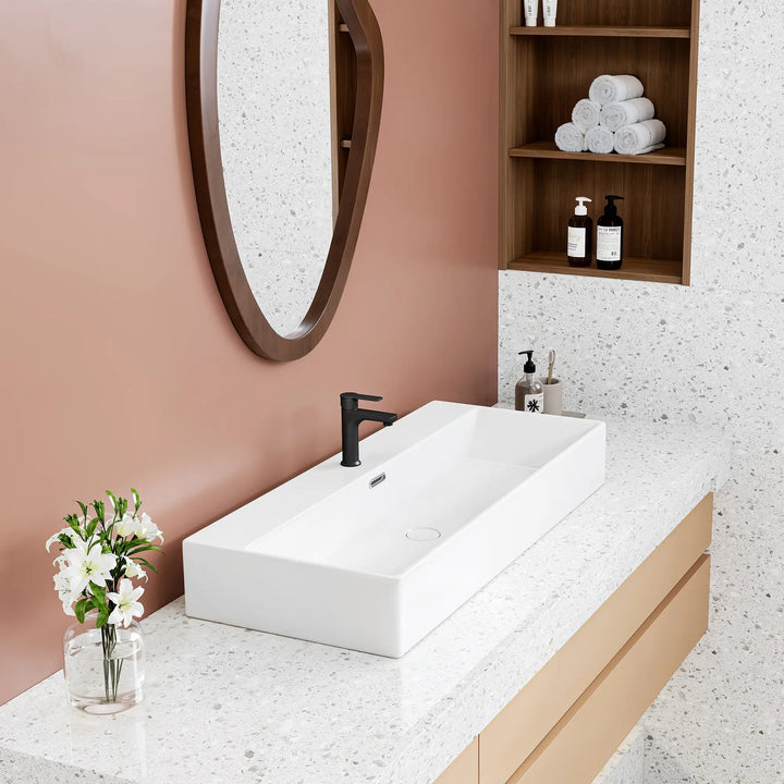 White rectangular ceramic vessel sink with black faucet