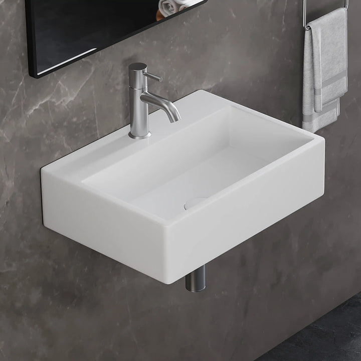 White rectangular wall-mounted solid surface bathroom sink with brushed nickel faucet