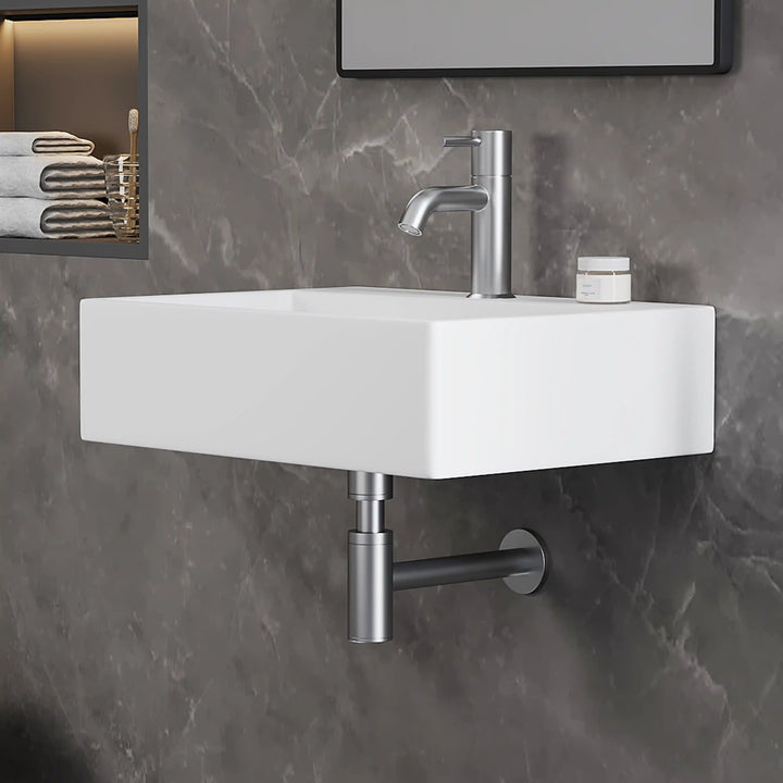 White rectangular wall-mounted ceramic sink with brushed nickel faucet &amp; drain pipe