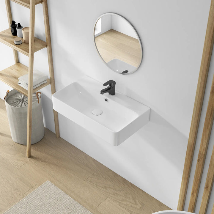 White rectangular wall-mounted ceramic sink, black faucet.