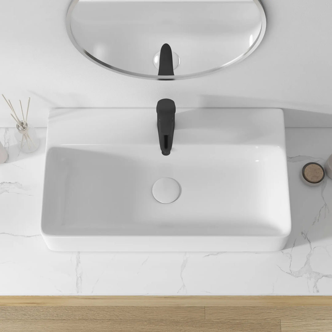 White rectangular ceramic sink with black faucet, overhead view.