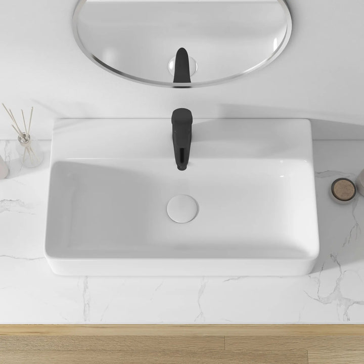 White rectangular ceramic sink with black faucet, overhead view.