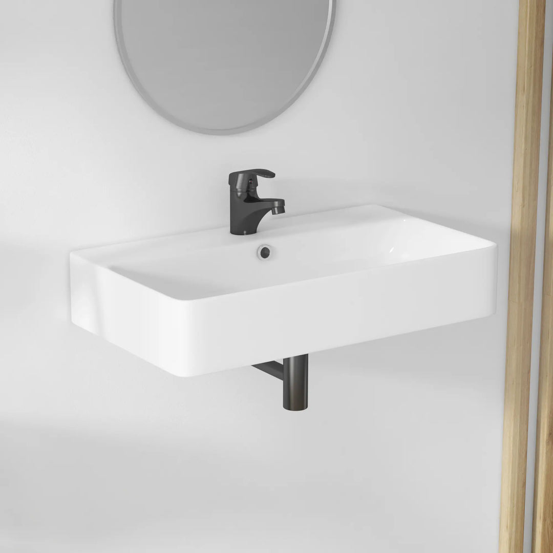 White ceramic wall-mounted sink, black faucet, exposed black trap.