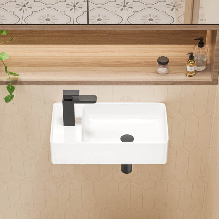 White wall-mounted rectangular ceramic sink with matte black faucet.